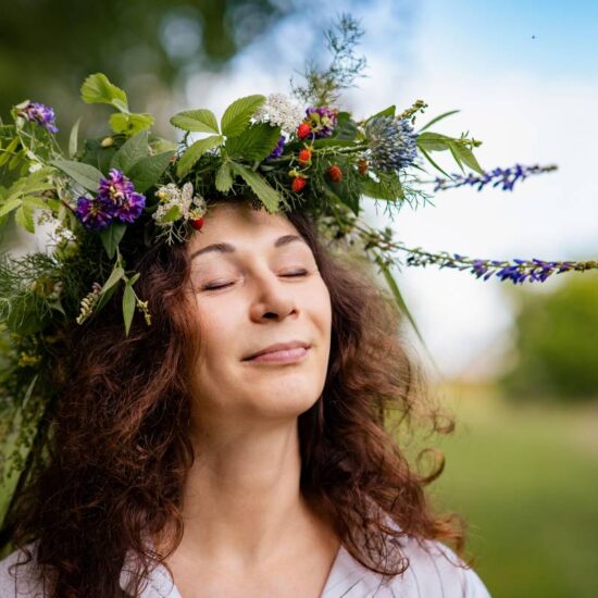 Natural portrait of woman with wildflowers, relaxed in rural summer field Well-Being: