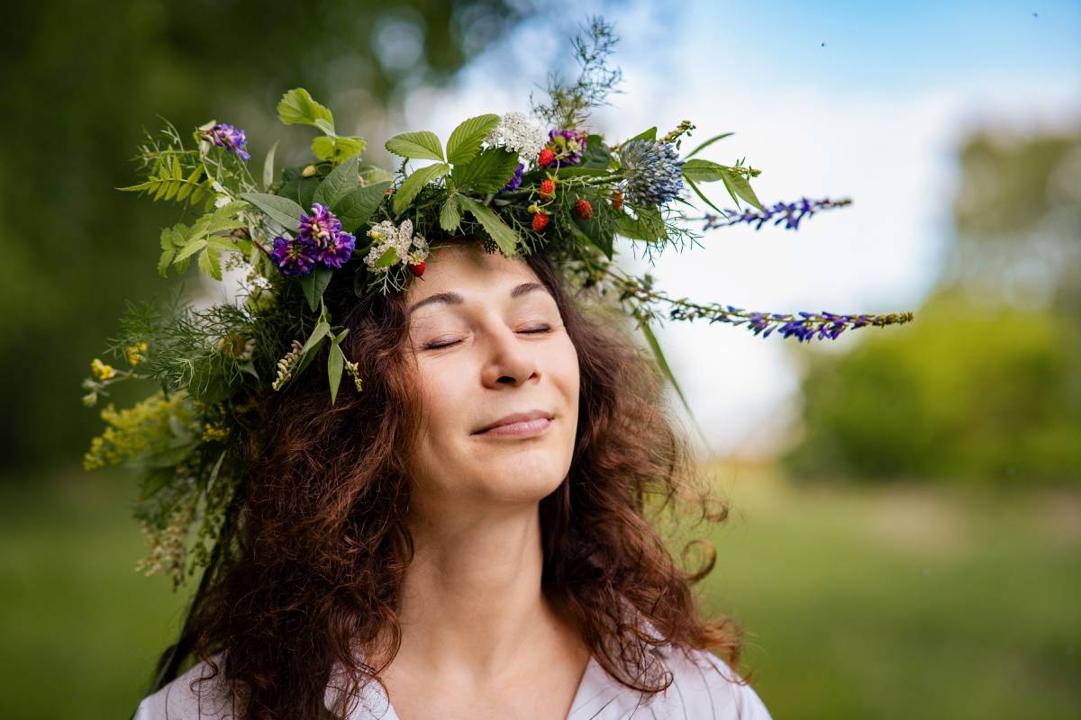Natural portrait of woman with wildflowers, relaxed in rural summer field Well-Being: